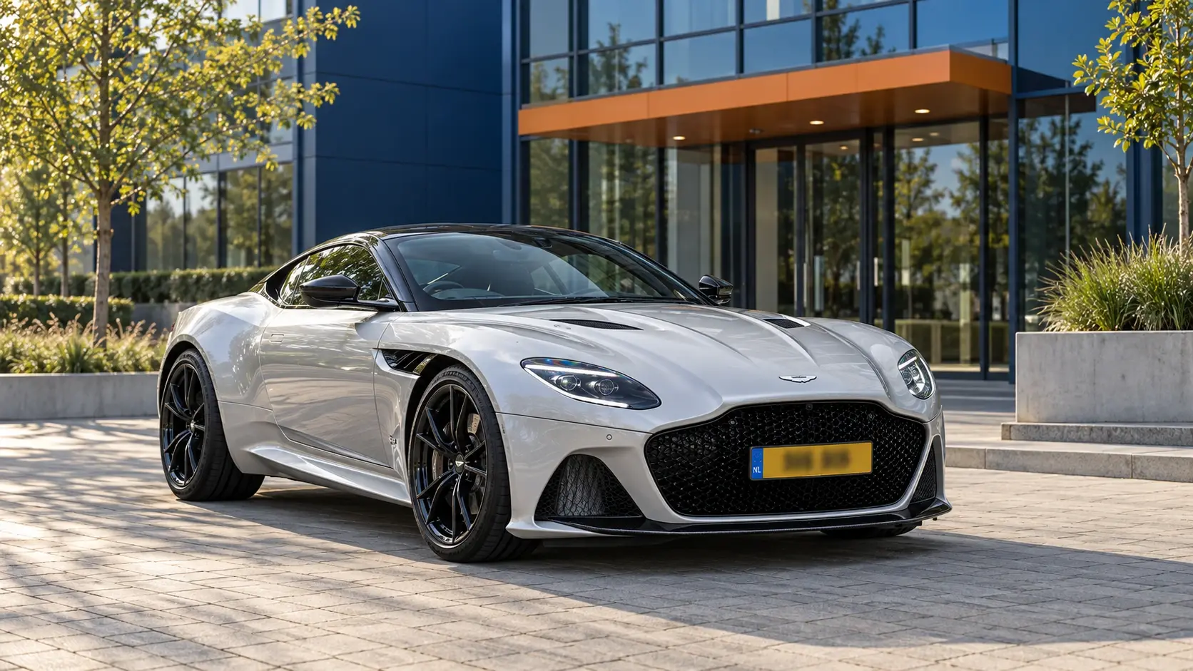 Zilveren Aston Martin DBS Superleggera Coupé van de recente V12-generatie, schuin van voren