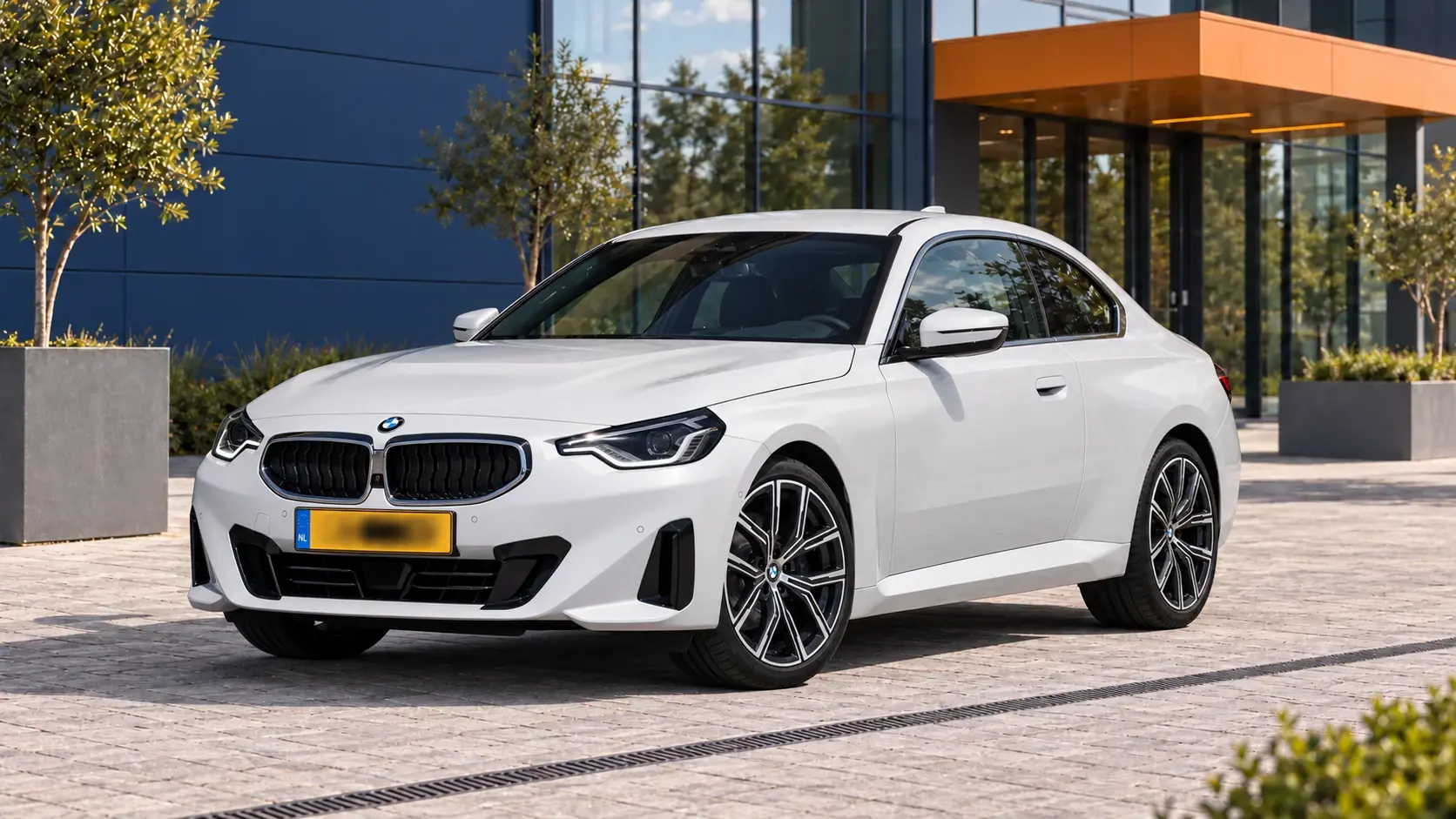 Witte BMW 220i Coupé van de G42-generatie in de eerdere introductieuitvoering, schuin van voren