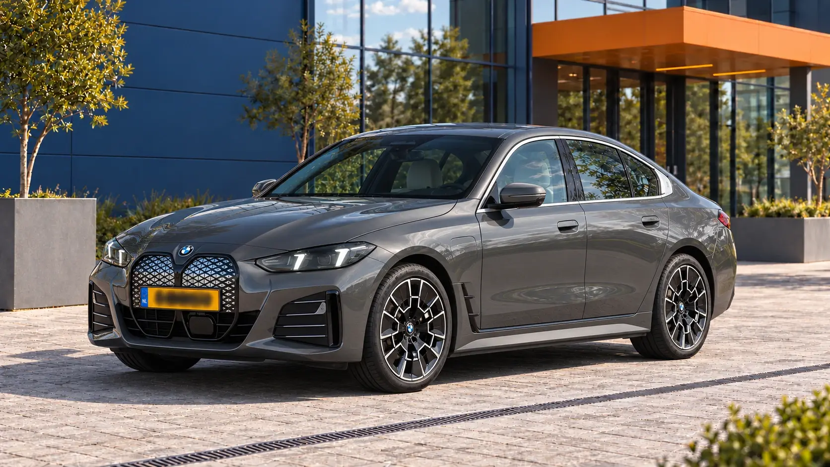 Grijze BMW i4 eDrive40 Gran Coupé met M Sport na de modelupdate van 2024, schuin van voren