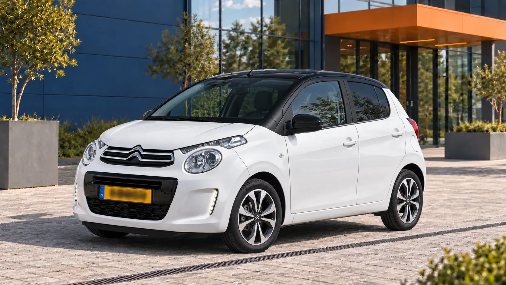 Witte Citroën C1 vijfdeurs met gesloten zwart dak, schuin van voren