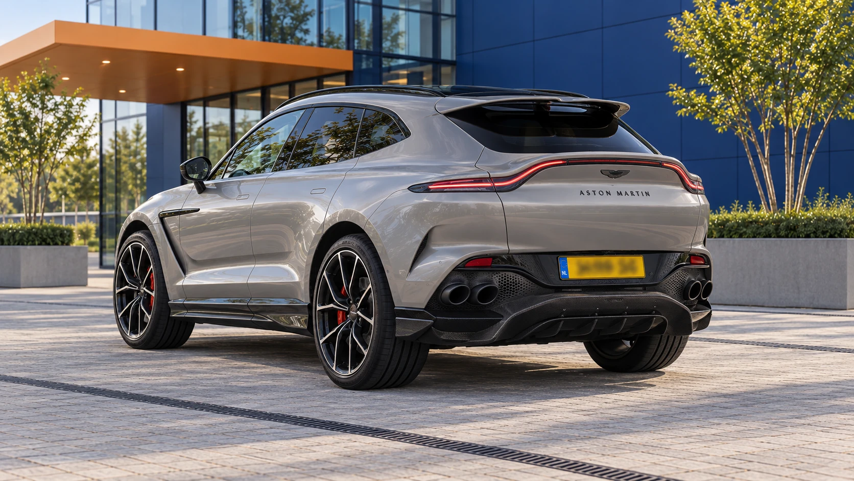 Grijze vernieuwde Aston Martin DBX707 van achteren met vier uitlaatpijpen naast elkaar