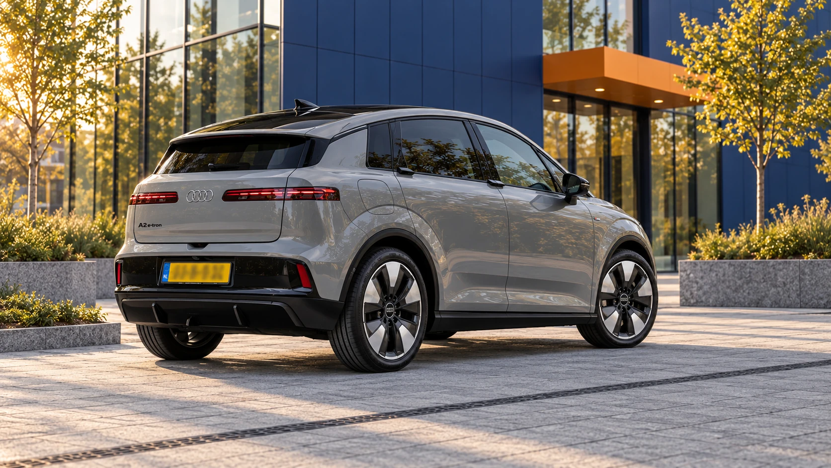 Grijze Audi A2 e-tron van de nieuwe generatie, schuin van achteren met aparte horizontale achterlichten