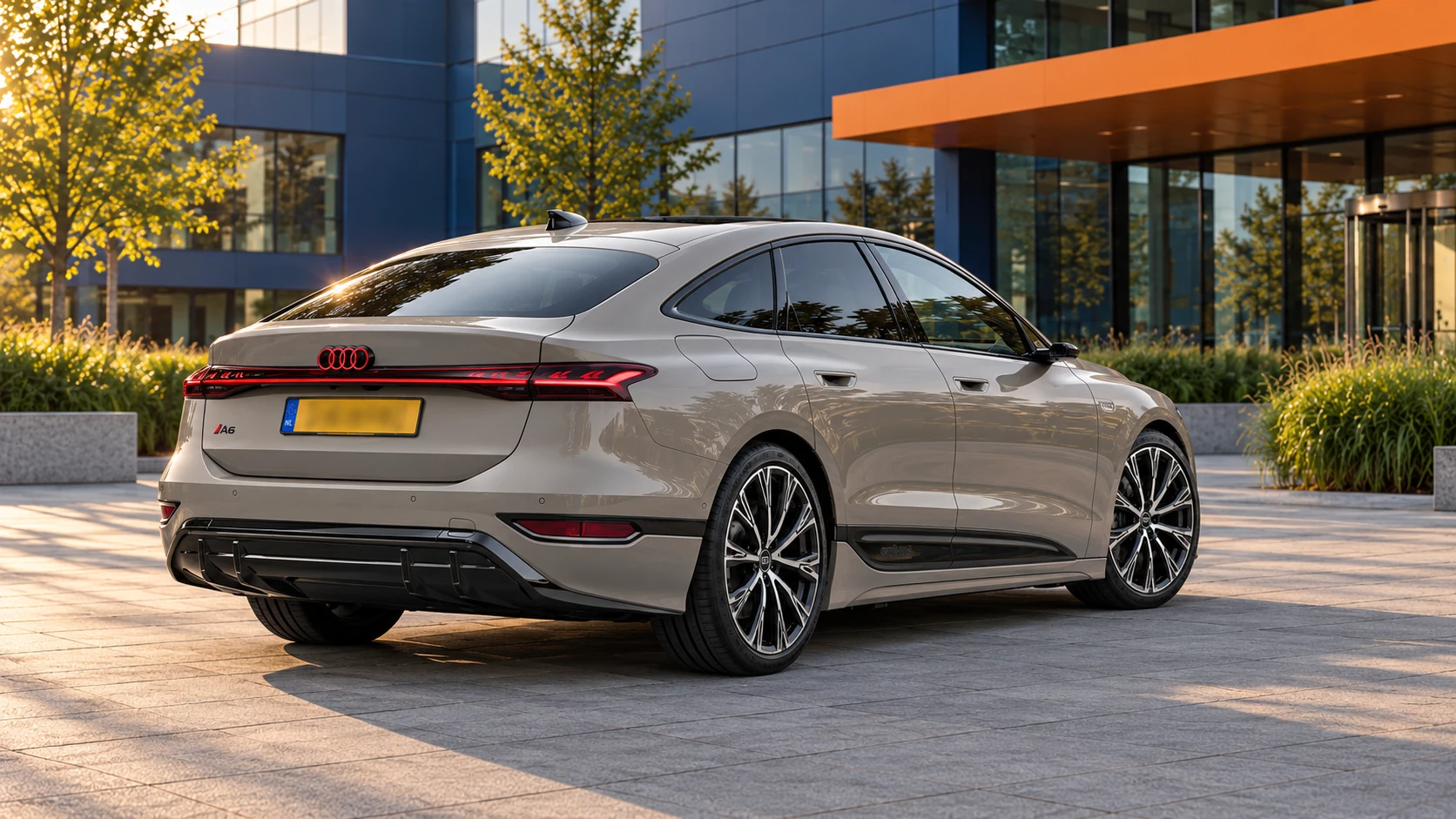 Grijze Audi A6 Sportback e-tron vanaf 2024, gewone elektrische liftback schuin van achteren met aflopende daklijn en gele Nederlandse kentekenplaat