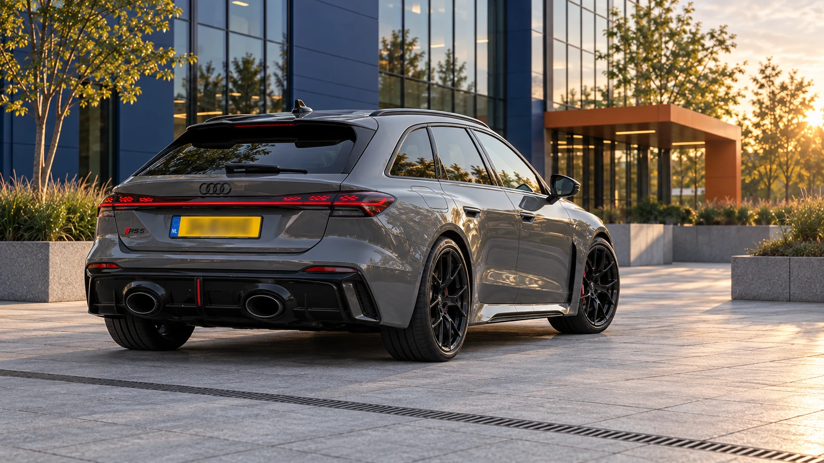 Nieuwe grijze Audi RS5 Avant uit 2026 schuin van achteren met doorlopende achterlichten