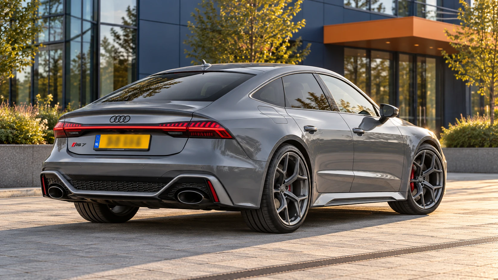 Achterzijde van een grijze Audi RS7 Sportback performance C8 met grote achterklep en twee ovale uitlaatopeningen