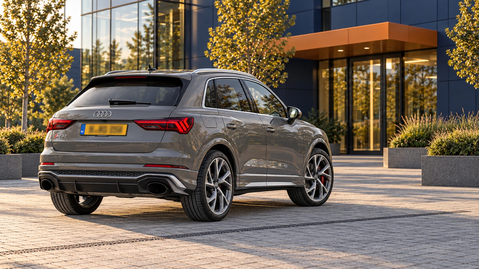 Grijze Audi RSQ3 F3 SUV van achteren met twee ovale uitlaatmonden