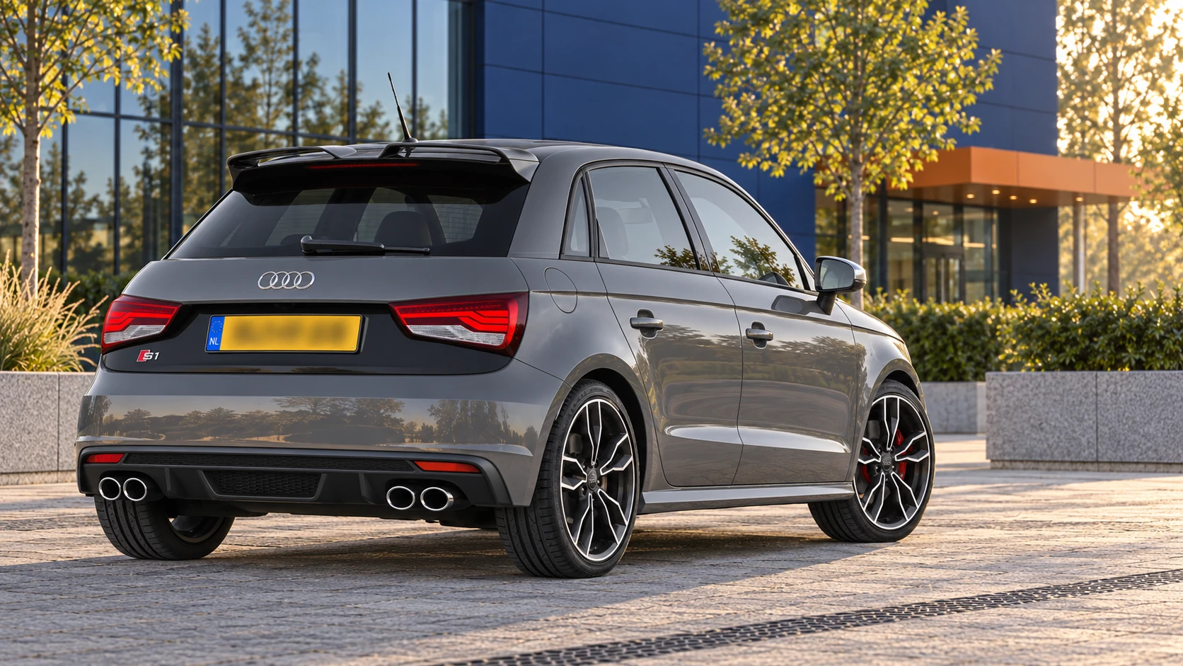 Achterzijde van een grijze vijfdeurs Audi S1 Sportback met vier uitlaatopeningen