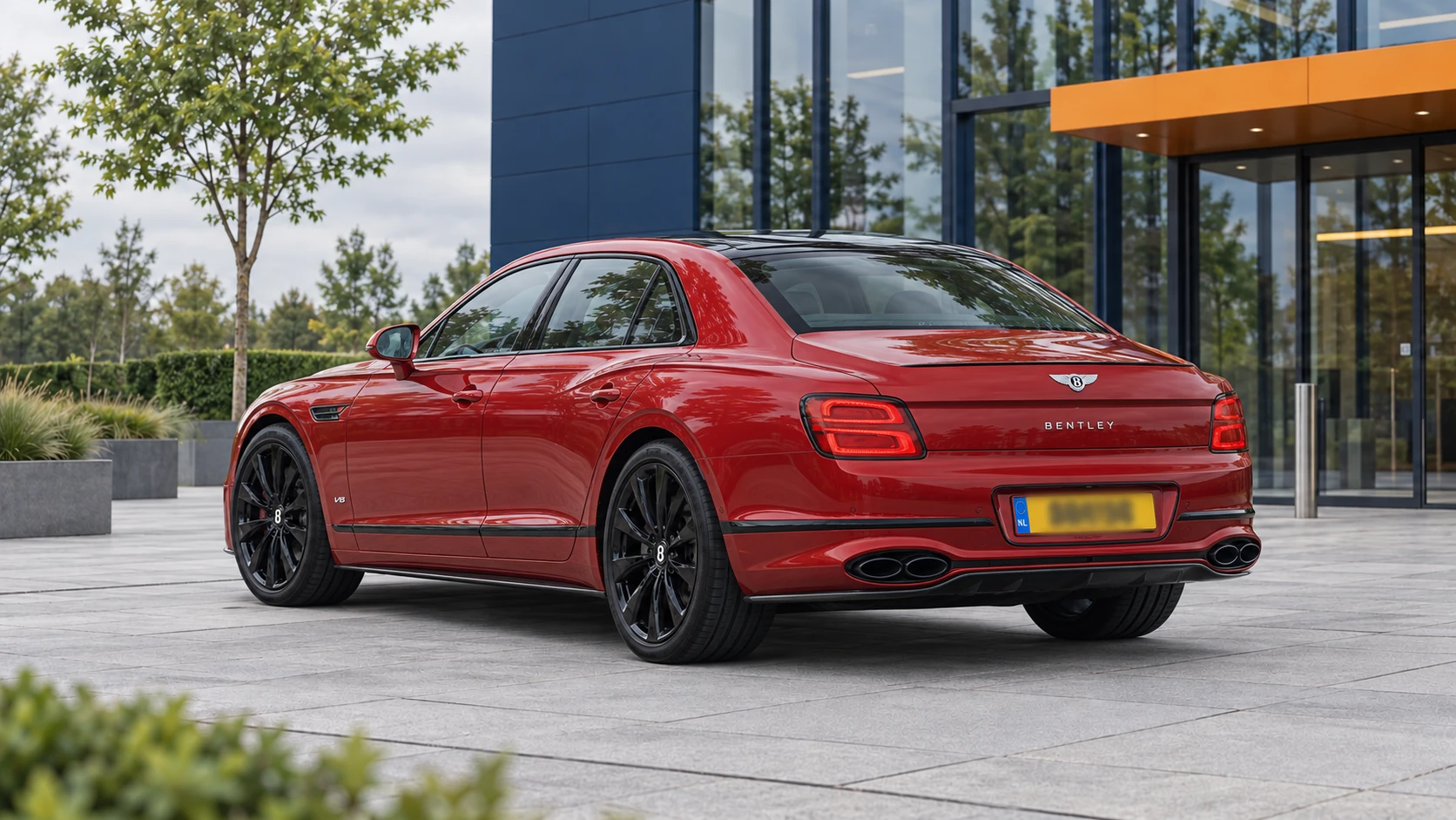 Rode Bentley Flying Spur V8 van achteren met vier ovale uitlaatopeningen