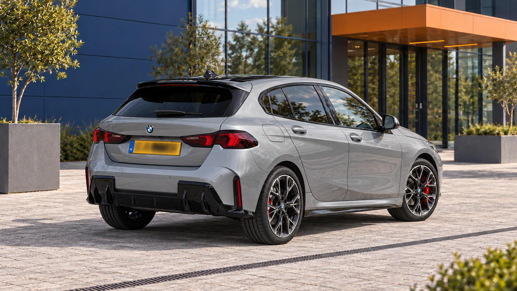 Achterzijde van een grijze BMW 120 F70 met M Sport-pakket en zwart dak