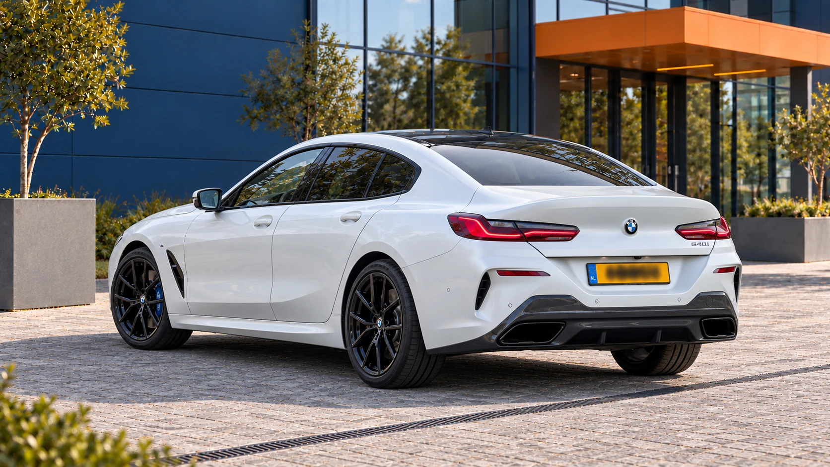 Achterzijde van een witte BMW 840i Gran Coup&eacute; uit de oorspronkelijke G16-generatie