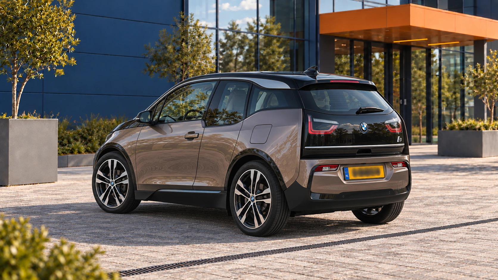 Achterzijde van een grijsbeige BMW i3 120 Ah uit de compacte I01-generatie