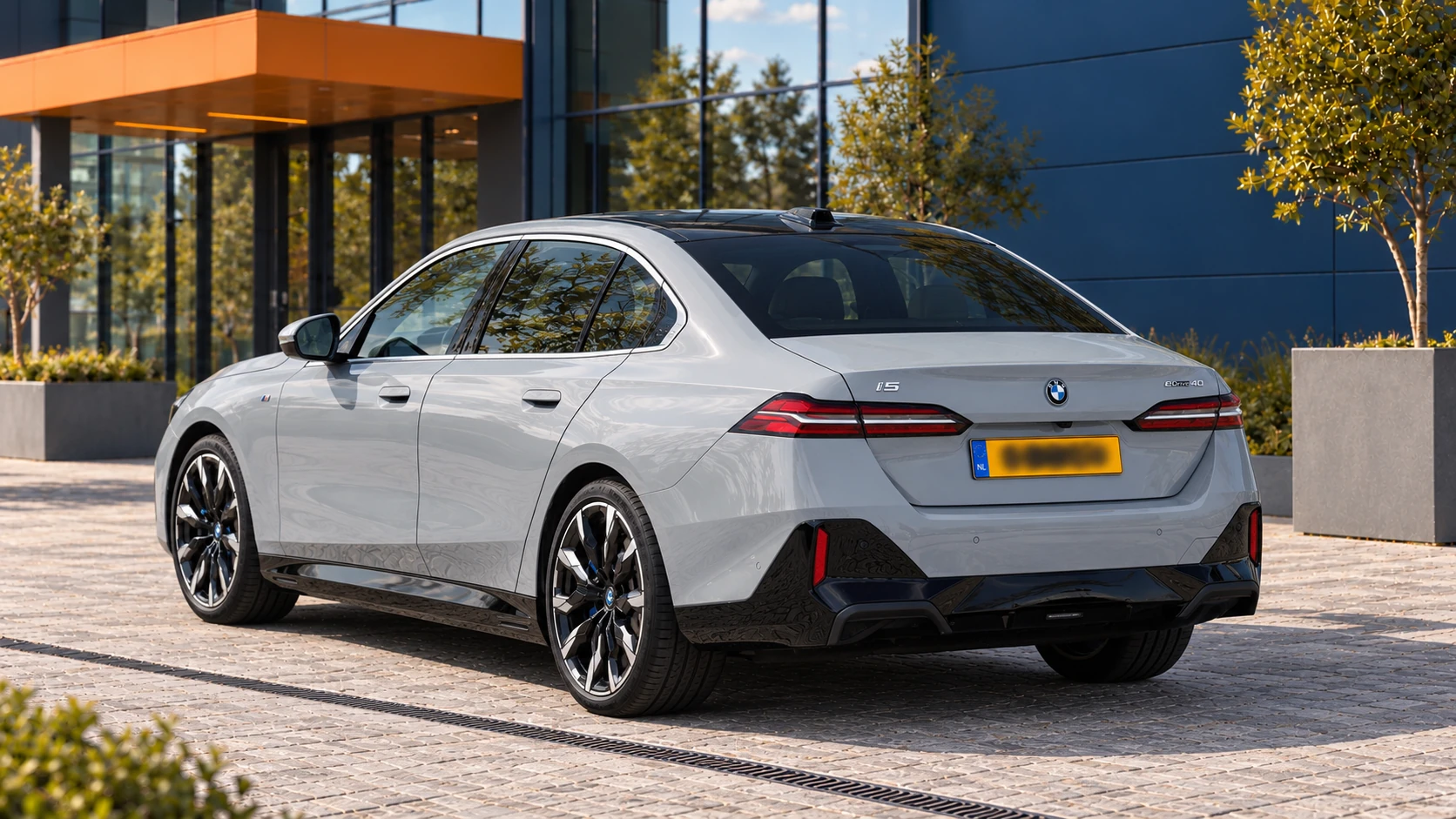 Achterzijde van een lichtgrijze BMW i5 eDrive40 Sedan van de G60-generatie