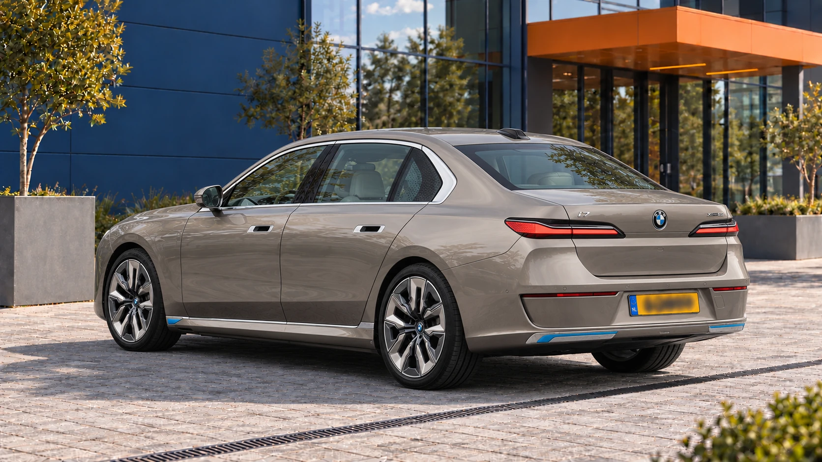 Achterzijde van dezelfde grijsbeige BMW i7 xDrive60 uit de oorspronkelijke G70-generatie