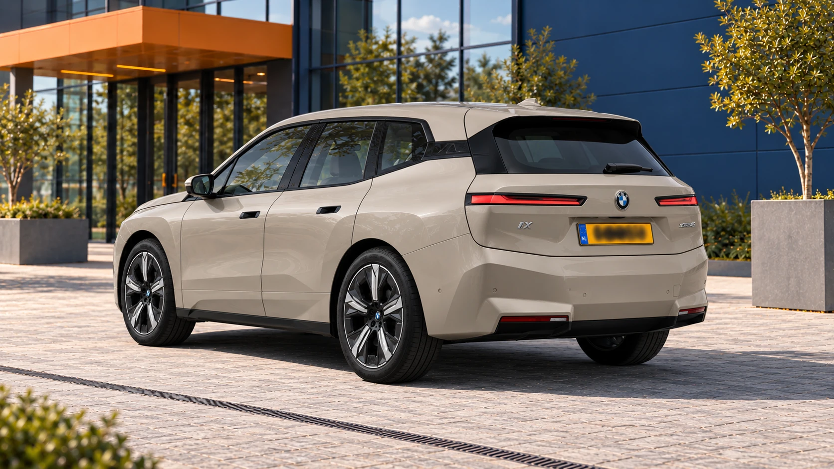 BMW iX xDrive45 in Dune Grey van schuin achteren