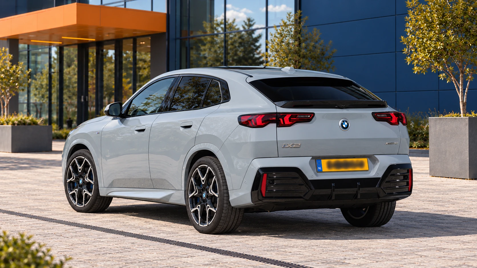 BMW iX2 xDrive30 in Brooklyn Grey met M Sport, schuin van achteren