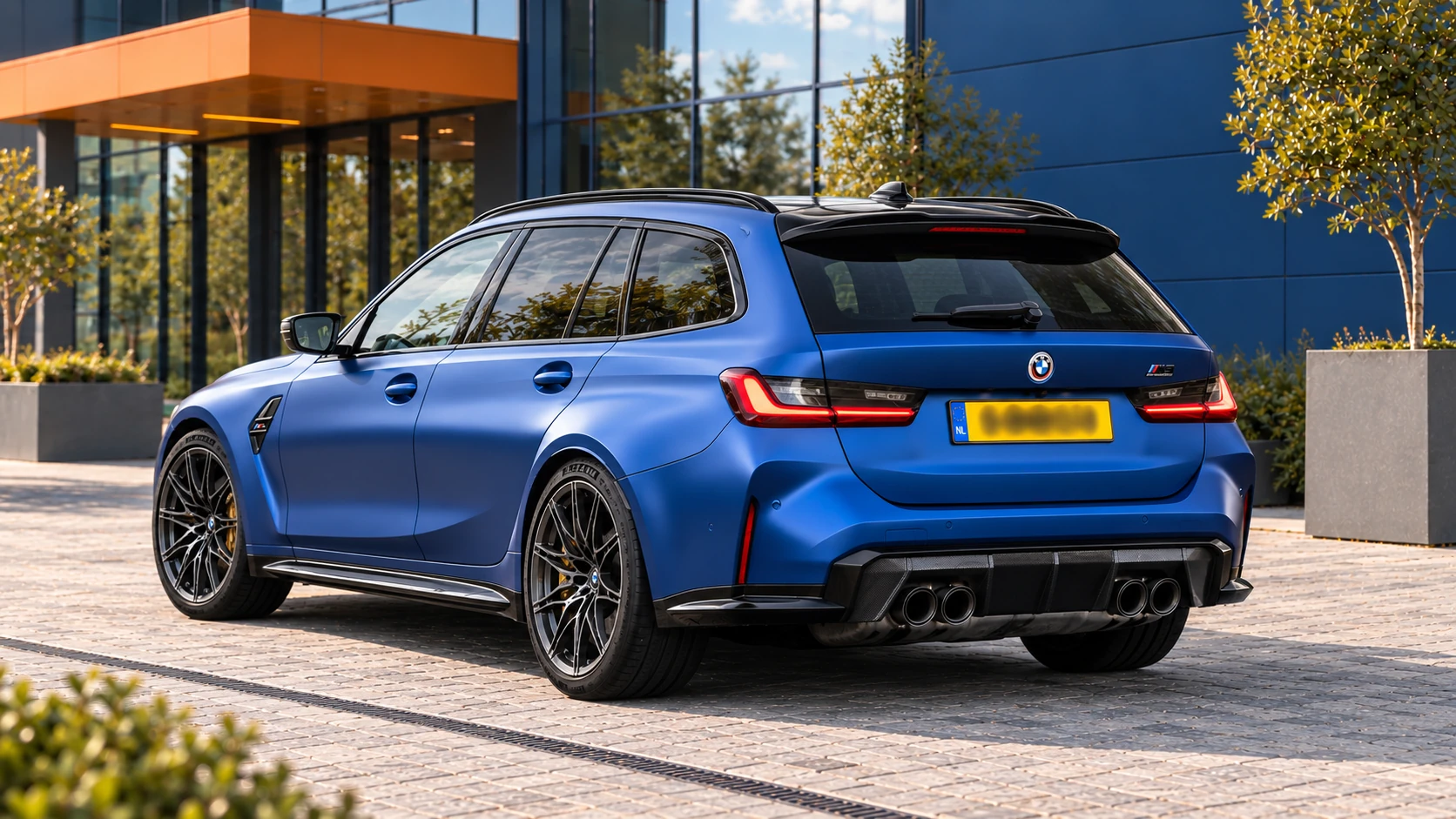 Achterzijde van dezelfde blauwe BMW M3 Competition Touring met vier uitlaatpijpen