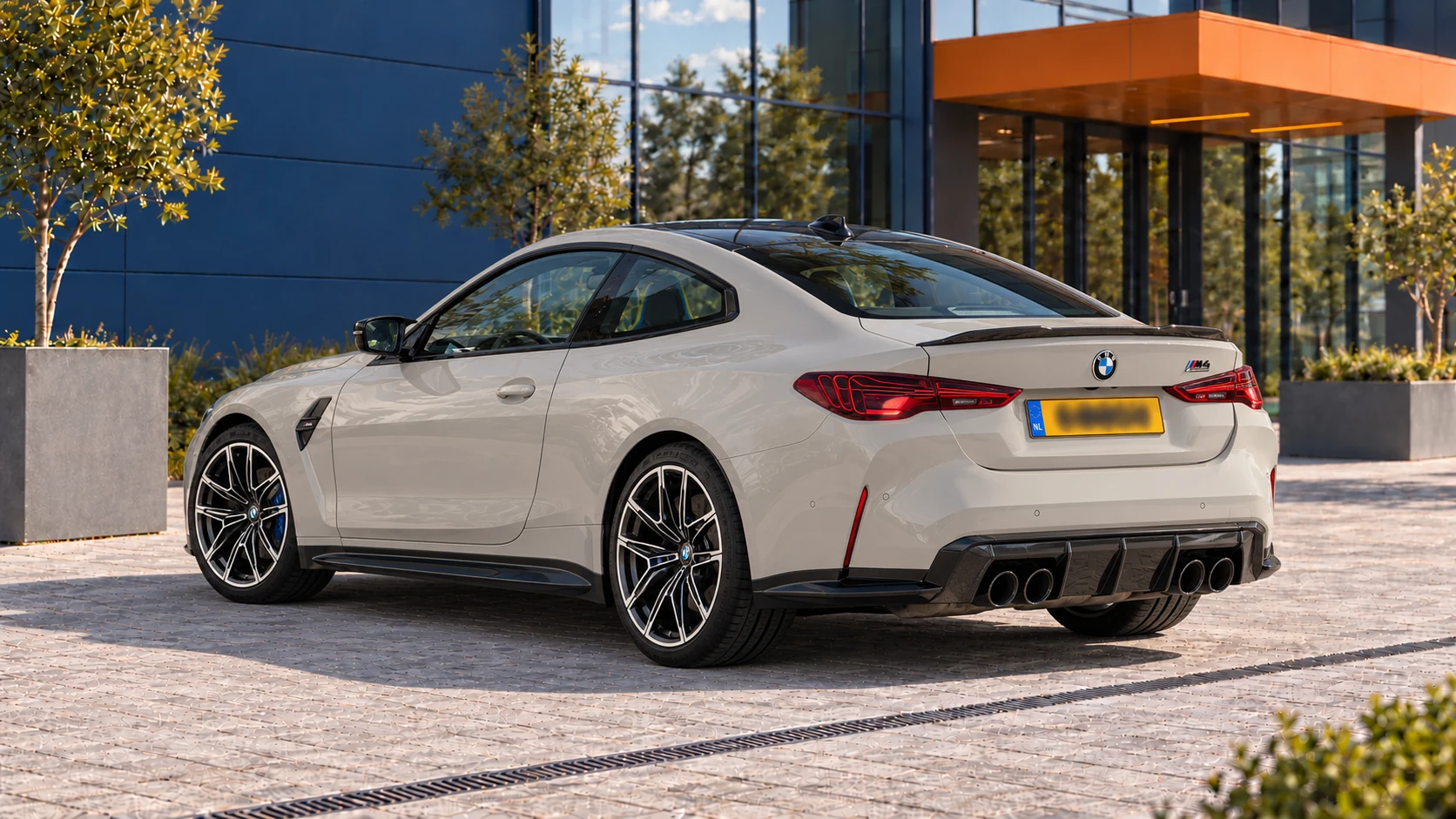 Achterzijde van dezelfde BMW M4 Competition Coup&eacute; met laserachterlichten en vier uitlaatpijpen