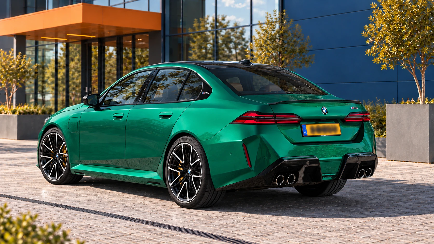 Achterzijde van dezelfde groene BMW M5 Sedan met vier uitlaatpijpen