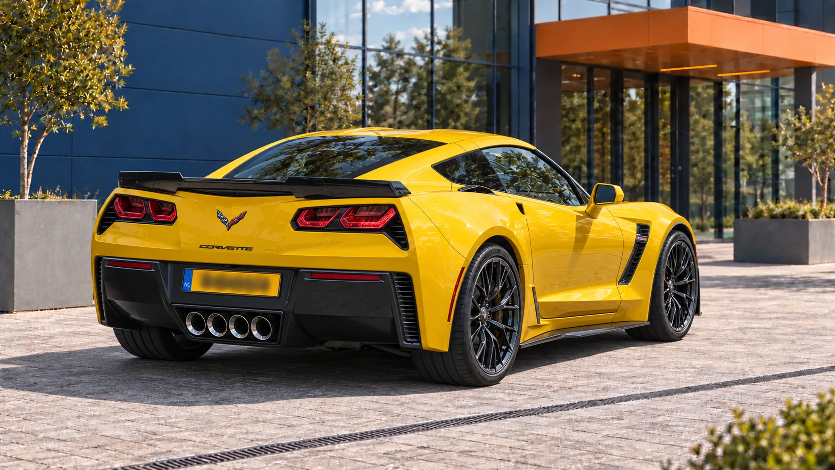 Achterzijde van dezelfde gele Corvette C7 Z06 met vier centrale uitlaatpijpen