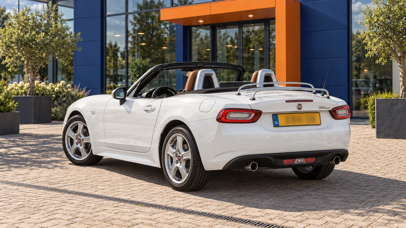 Achterzijde van dezelfde witte Fiat 124 Spider met geopend dak