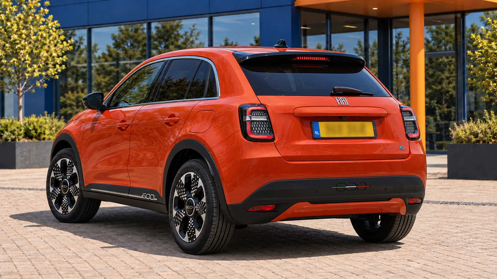 Achterzijde van dezelfde oranje elektrische Fiat 600e La Prima