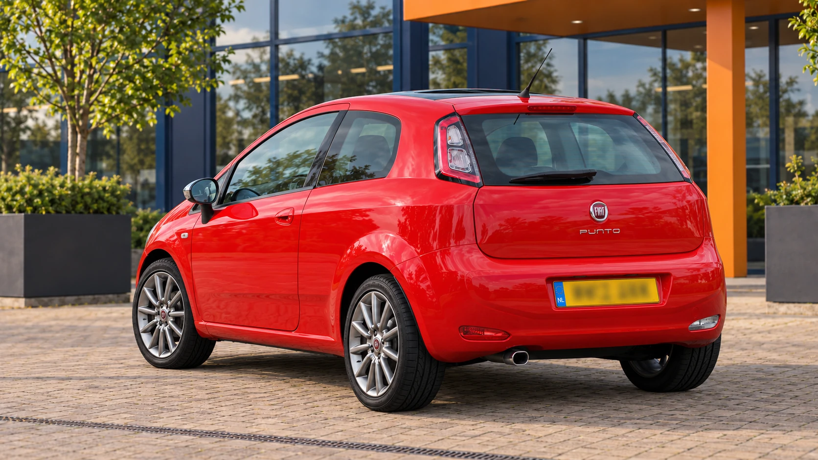 Achterzijde van dezelfde rode driedeurs Fiat Punto