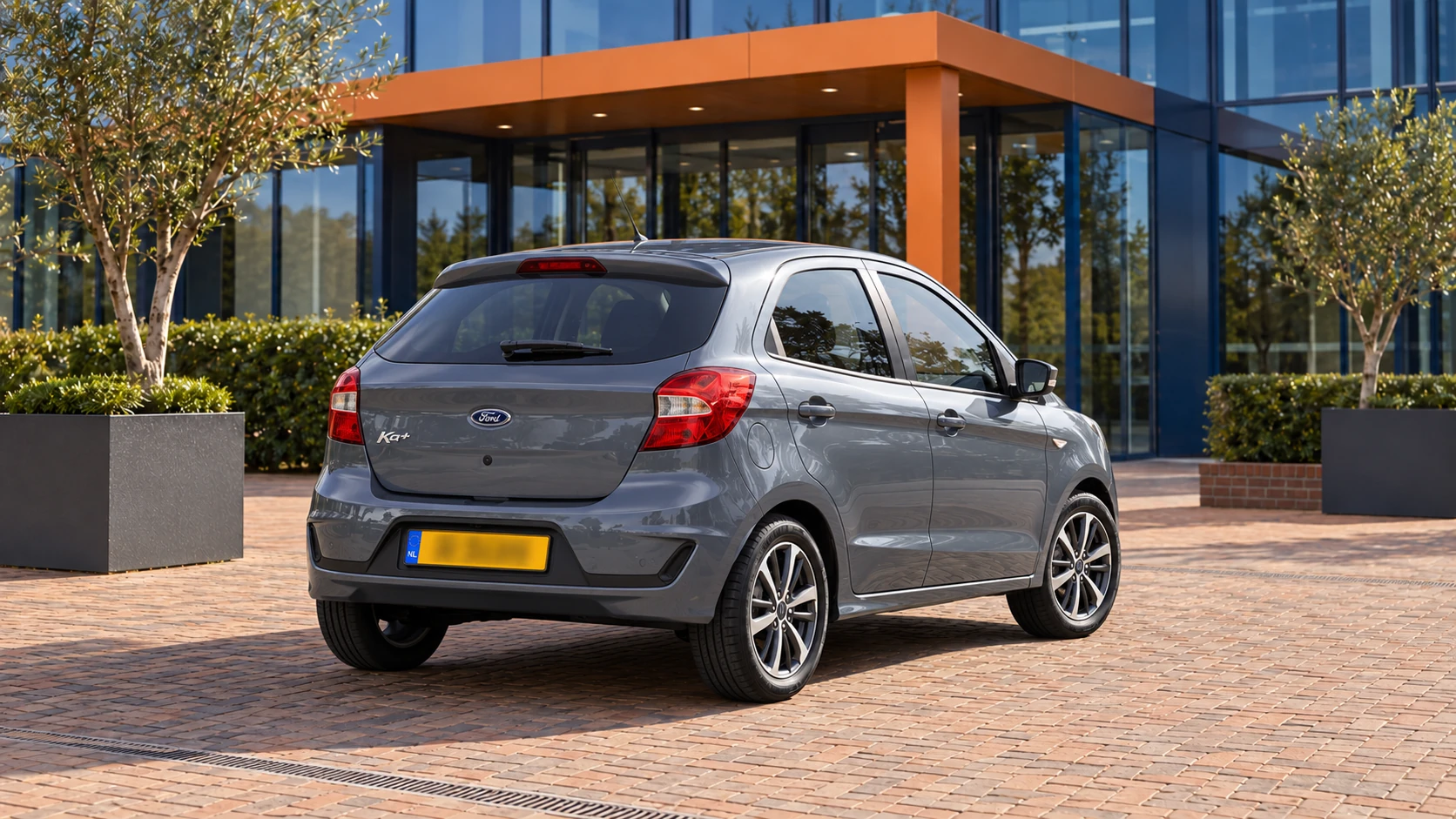 Achterzijde van dezelfde grijsblauwe Ford Ka+