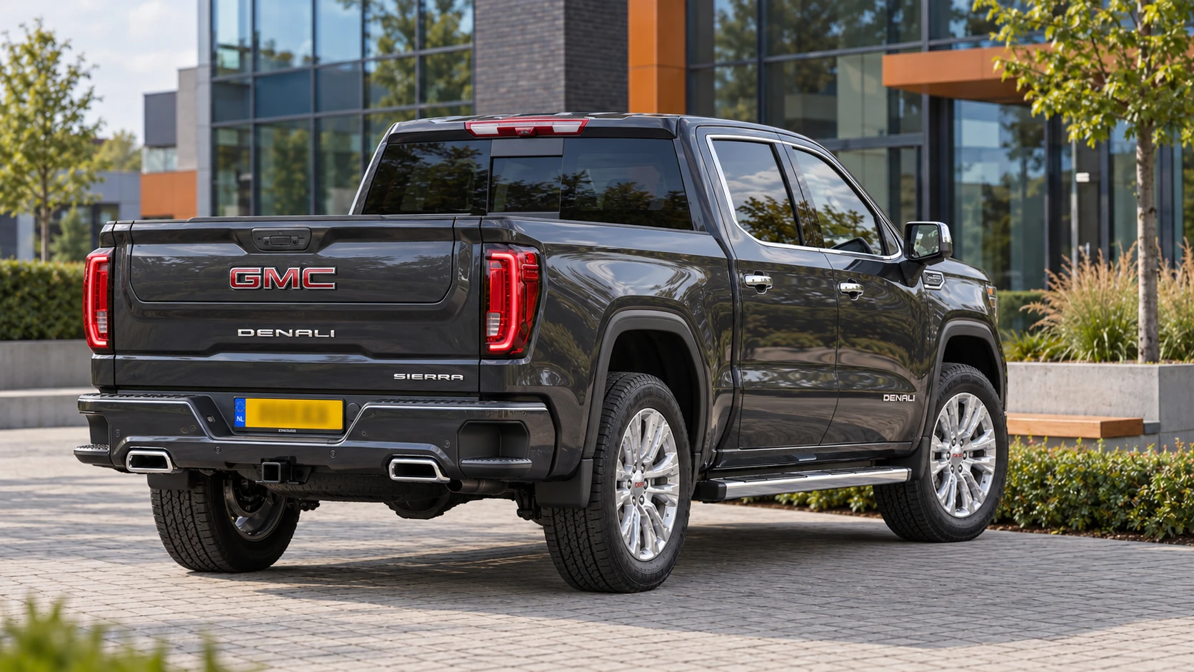Dezelfde donkergrijze GMC Sierra 1500 pickup, schuin van achteren