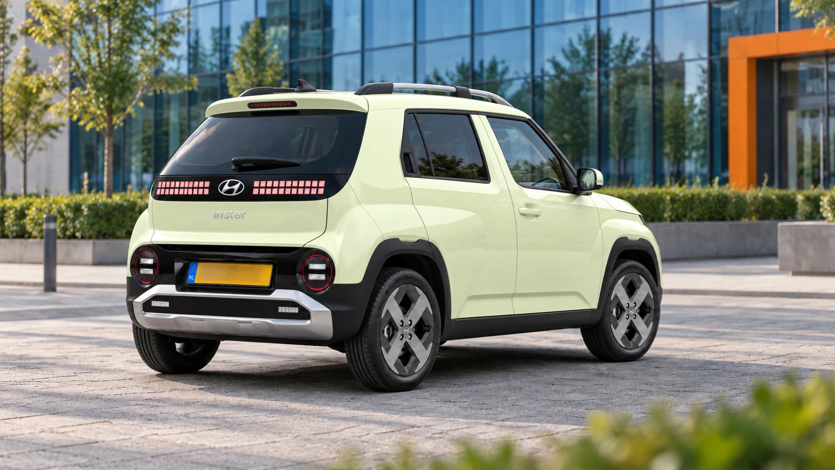 Dezelfde lichtgele Hyundai Inster, schuin van achteren