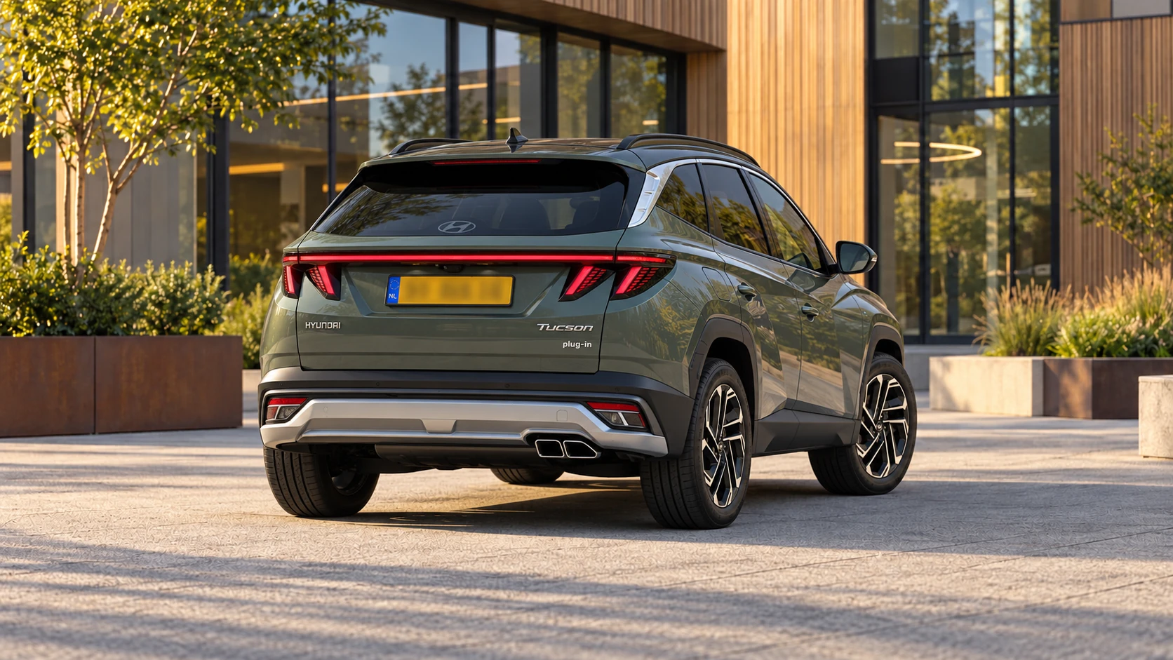 Dezelfde groene Hyundai TUCSON Plug-in Hybrid, schuin van achteren