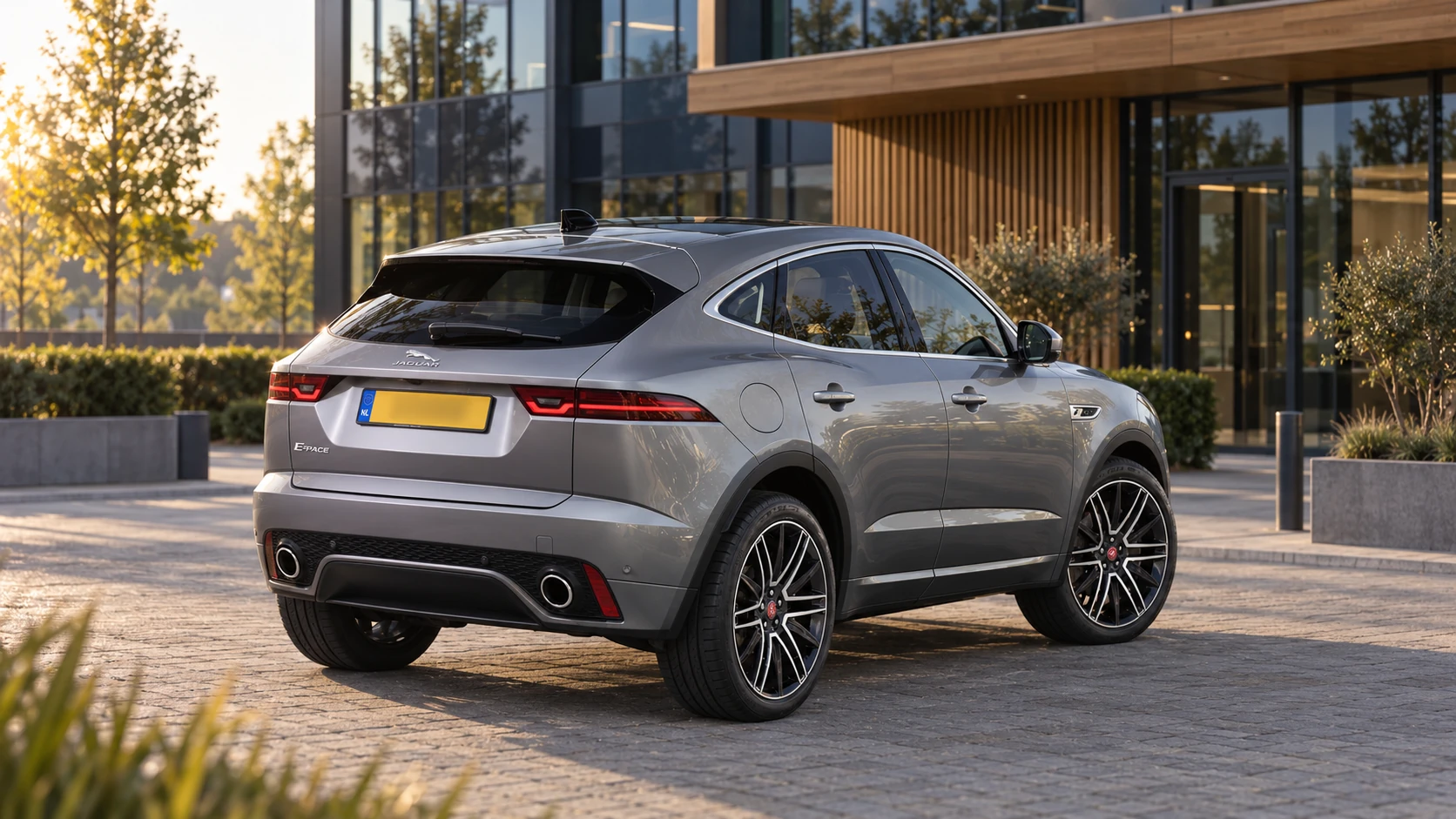Dezelfde zilvergrijze Jaguar E-Pace SUV, schuin van achteren