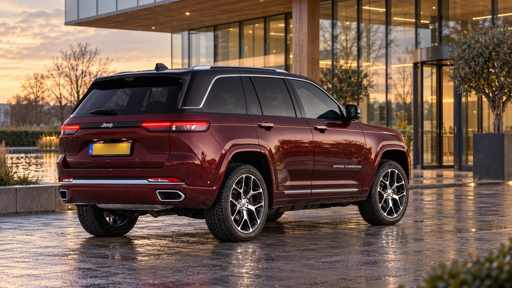 Dezelfde rode Jeep Grand Cherokee SUV, schuin van achteren