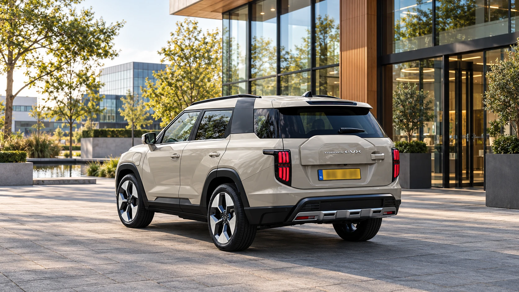 Dezelfde beige KGM Torres EVX SUV, schuin van achteren