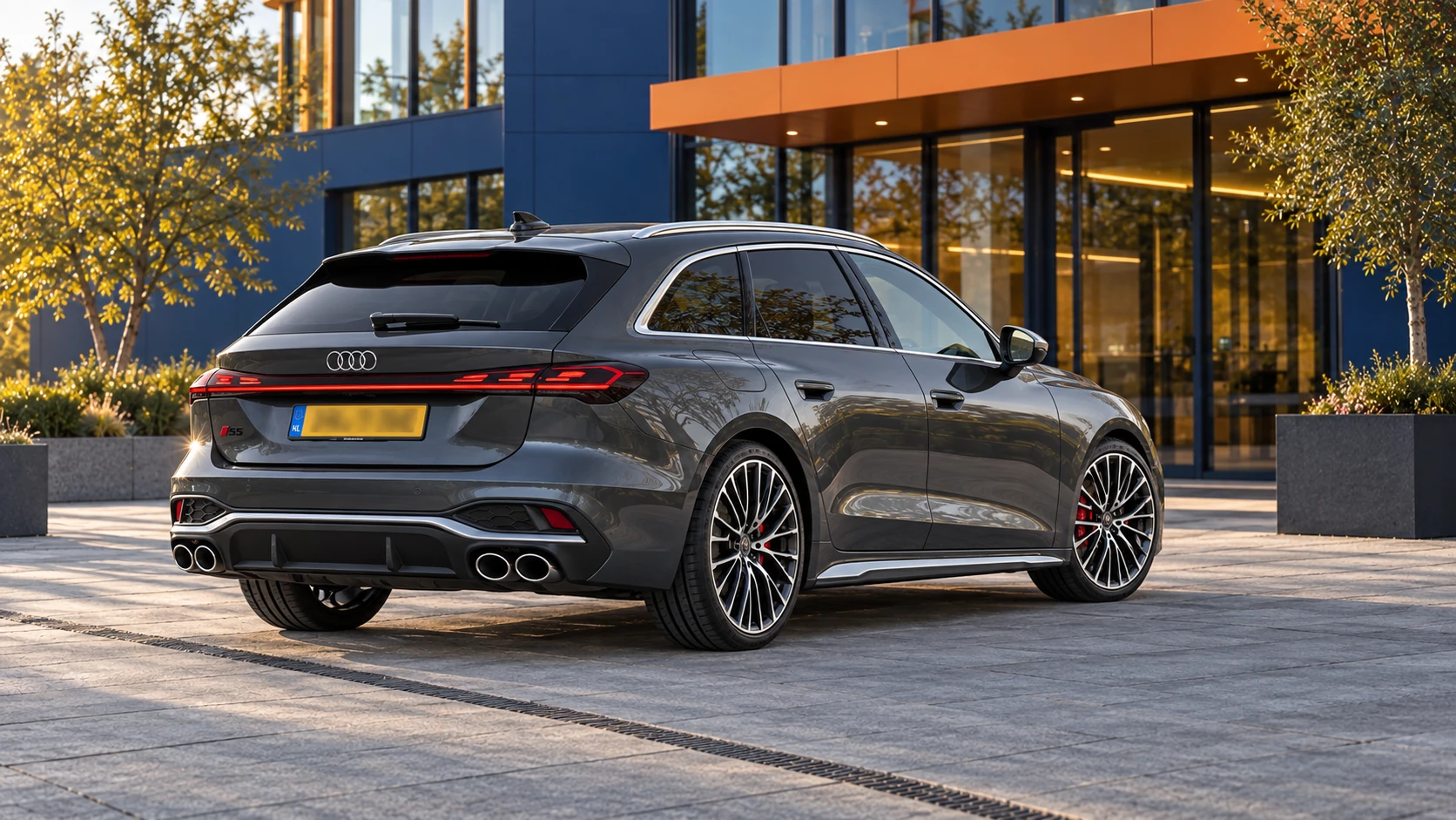 Grijze Audi S5 Avant van de nieuwe generatie vanaf 2024, schuin van achteren met onleesbare gele Nederlandse kentekenplaat