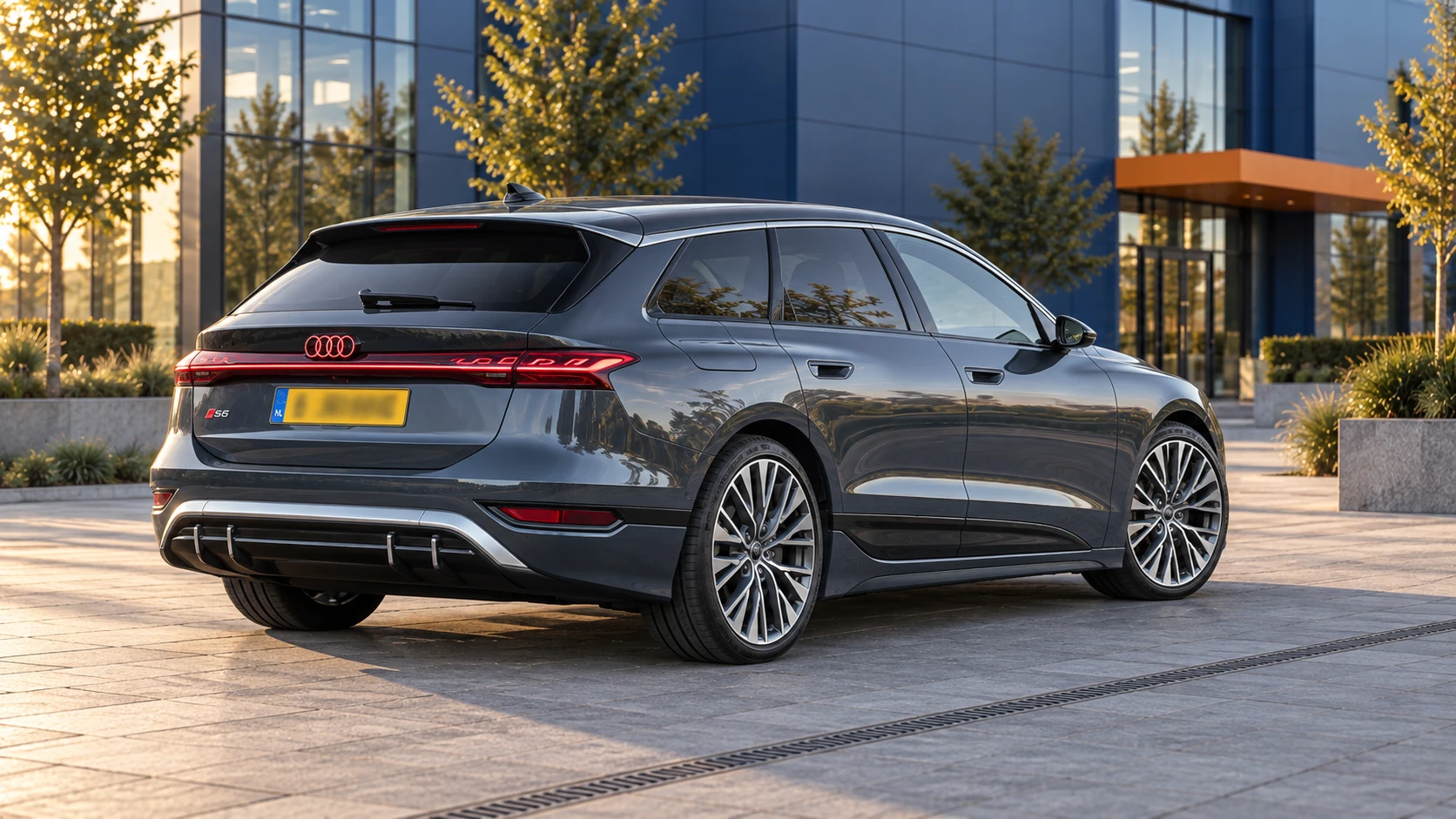 Grijze elektrische Audi S6 Avant e-tron van schuin achter, met doorlopende lichtbalk en geel Nederlands kenteken