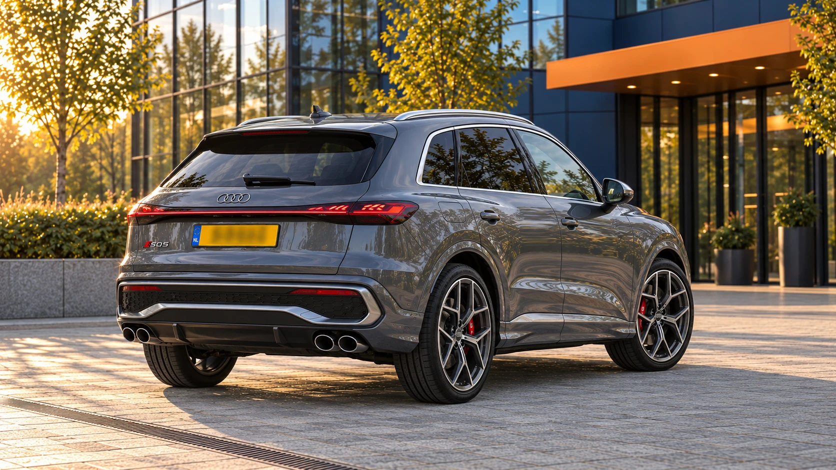 Achterzijde van een grijze nieuwe Audi SQ5 SUV met de gewone SUV-carrosserie en vier uitlaatopeningen