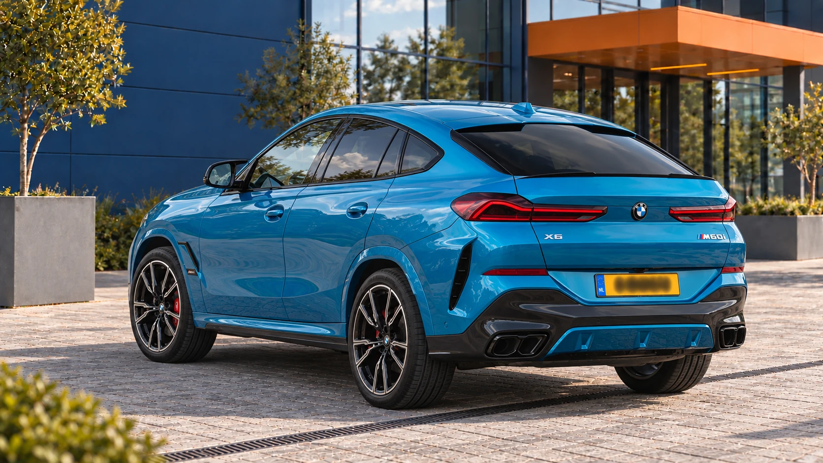 Achterzijde van dezelfde BMW X6 M60i xDrive met vier uitlaateindstukken