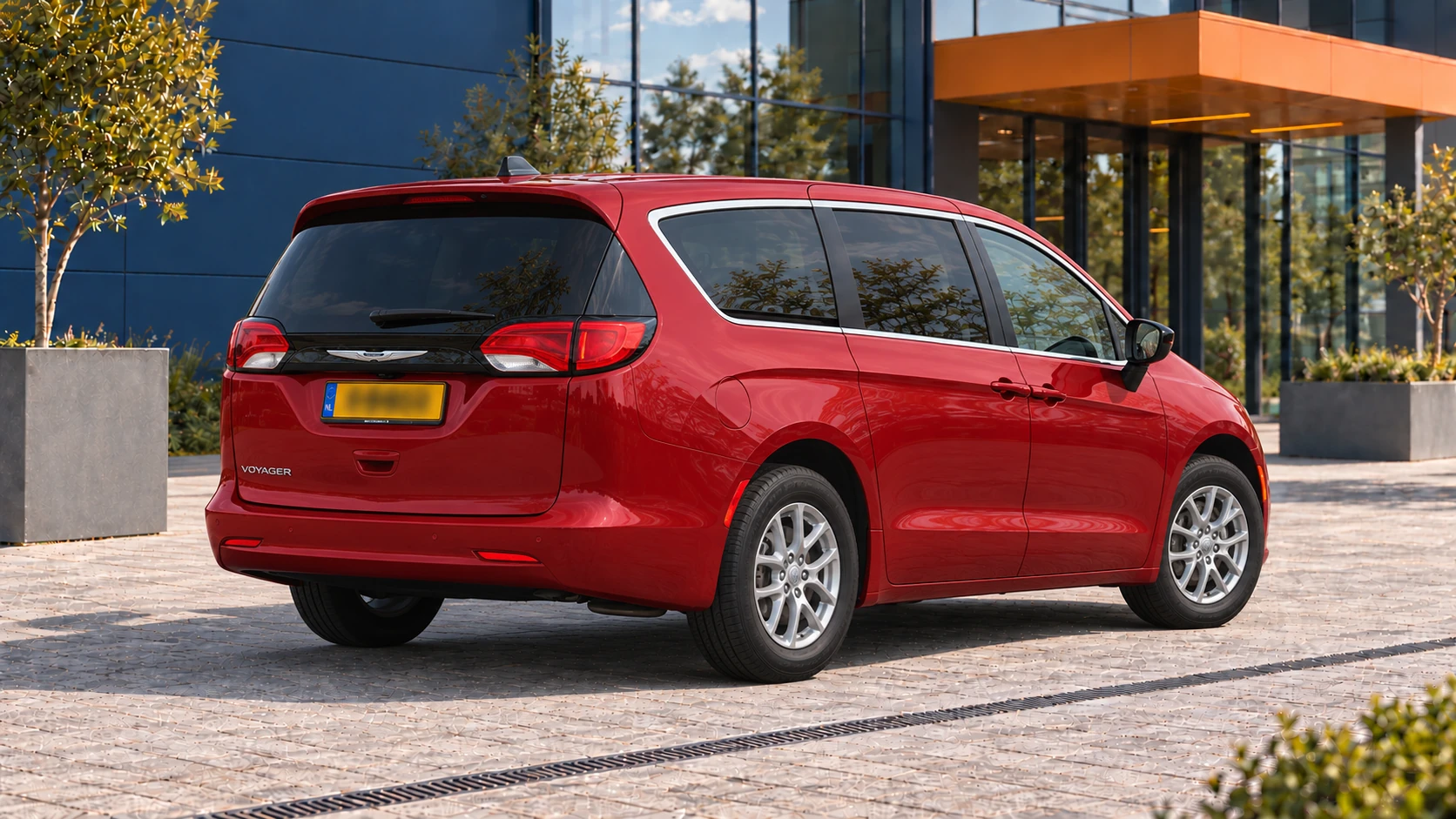 Achterzijde van dezelfde rode Chrysler Voyager LX