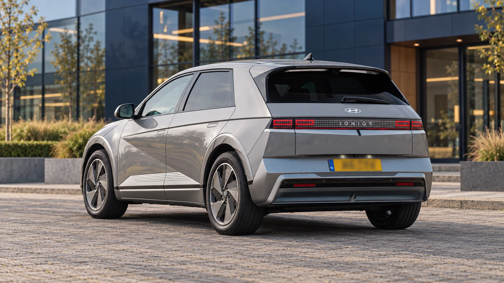 Dezelfde grijze Hyundai IONIQ 5 van de faceliftgeneratie, schuin van achteren