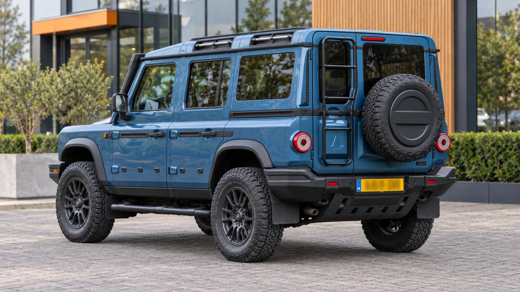 Dezelfde blauwe INEOS Grenadier Station Wagon, schuin van achteren