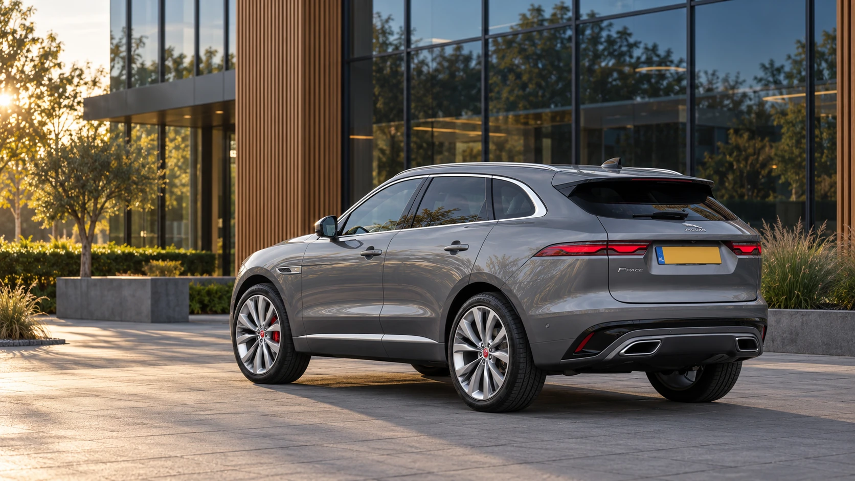 Dezelfde zilvergrijze Jaguar F-Pace SUV, schuin van achteren