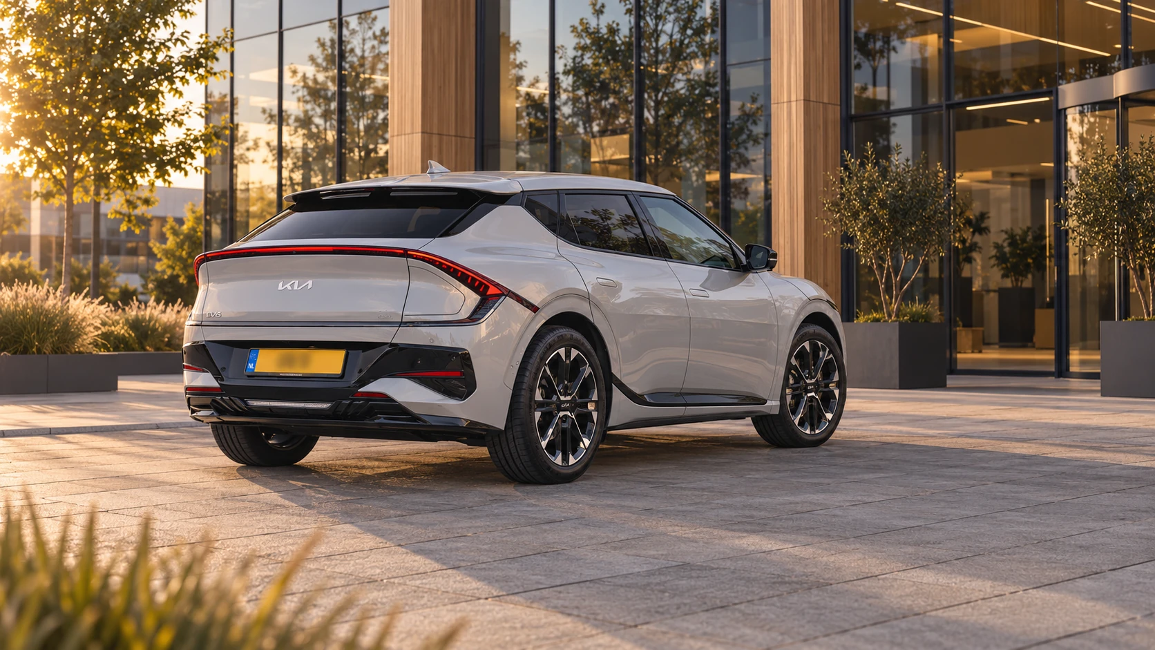 Dezelfde lichtgrijze Kia EV6 facelift, schuin van achteren